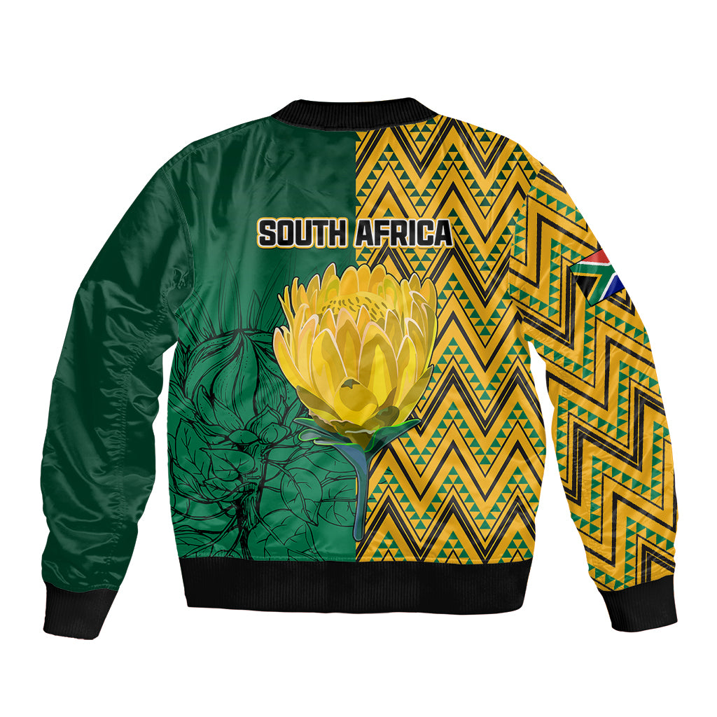 Unisex bomber jacket with green back, large yellow flower, and zigzag patterned panels.