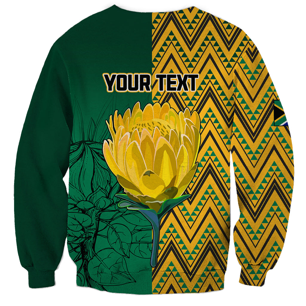 Dark green personalized sweatshirt back with protea flower, zigzag panels, and 'YOUR TEXT'