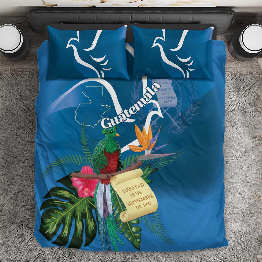 Blue bedding set flat on bed with two patterned pillows and quetzal flower duvet