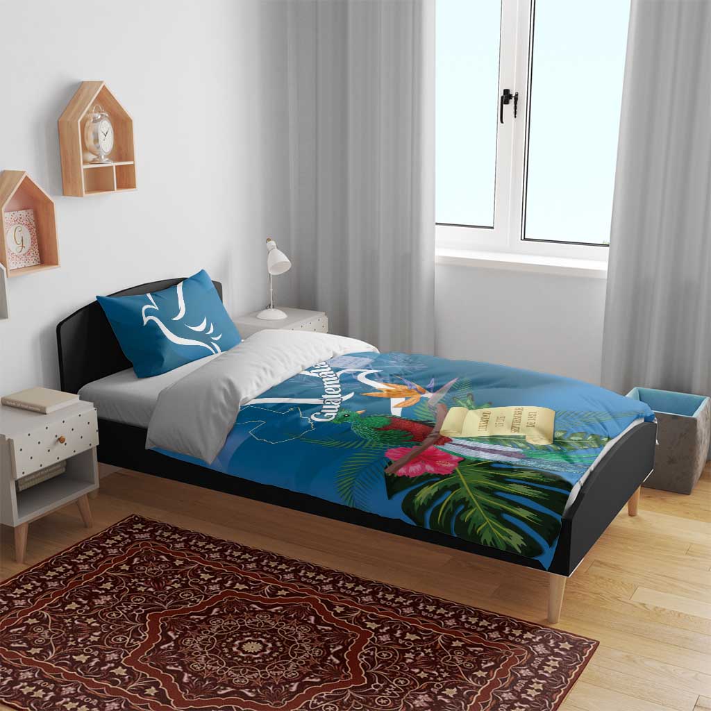 Blue bedding set on bed with two pillows and tropical quetzal flower graphic duvet