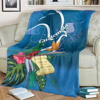 Blue tropical throw blanket on sofa with quetzal and Guatemala map banner design