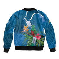Blue bomber jacket back with tropical quetzal, leaves, and flowers; ribbed cuffs and hem
