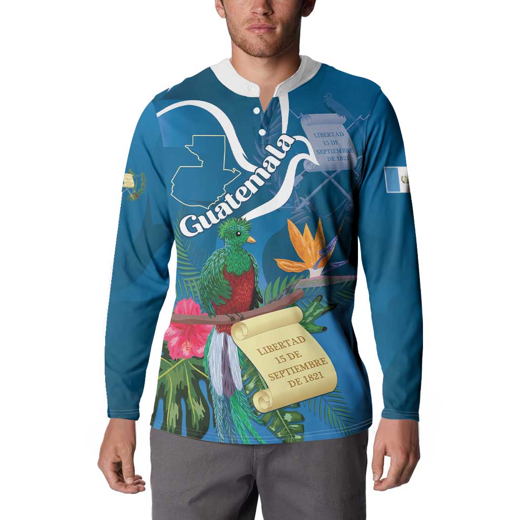 Blue henley sweatshirt worn by model, featuring tropical quetzal, leaves, and scroll graphic