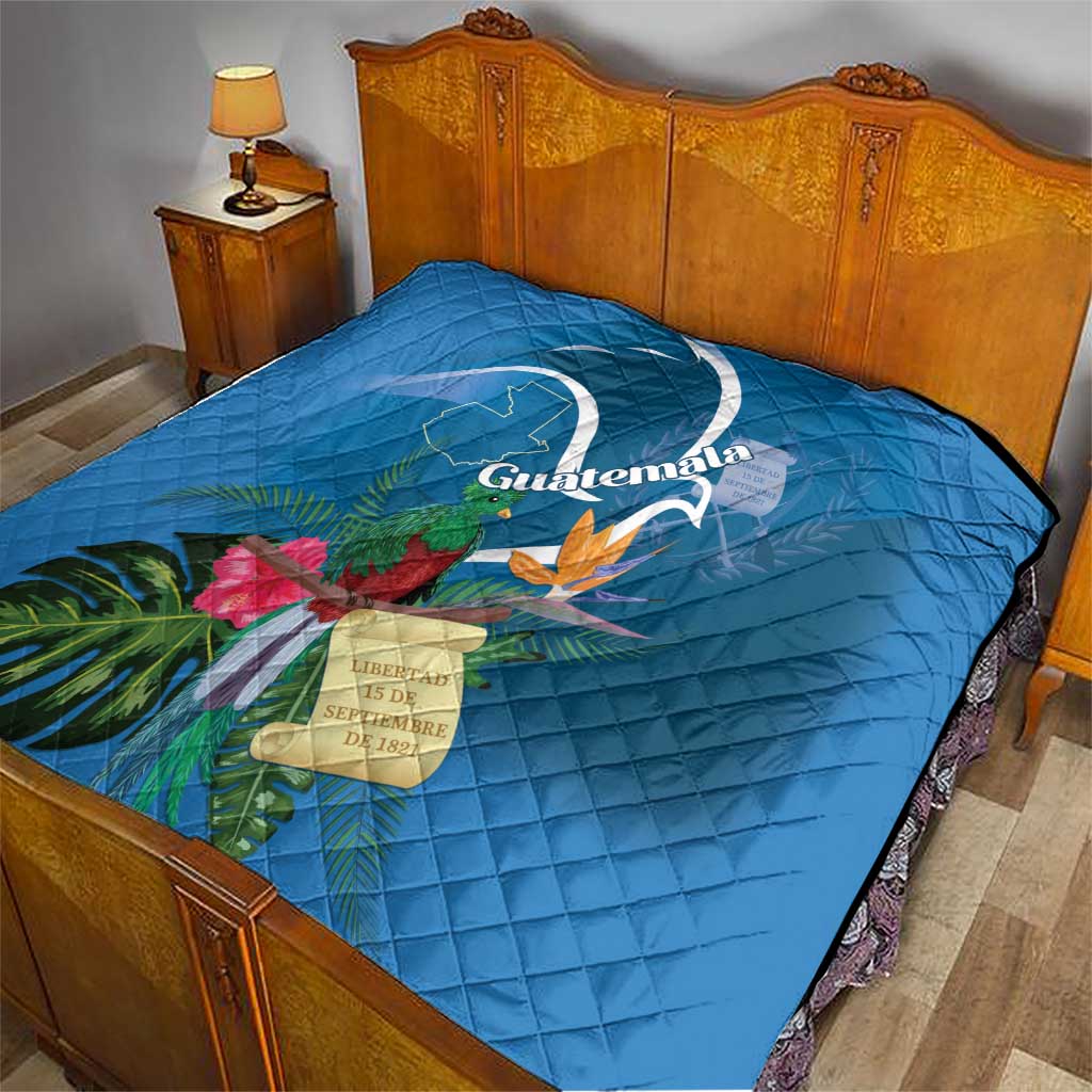 Blue quilt blanket with Quetzal and tropical flower print on a bed