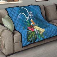 Blue quilt blanket on a sofa with Quetzal and tropical flowers design
