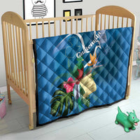 Blue quilt blanket on a crib with Quetzal and tropical flower artwork