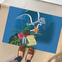 Blue rubber doormat with Guatemala crest, tropical flowers, and bird design