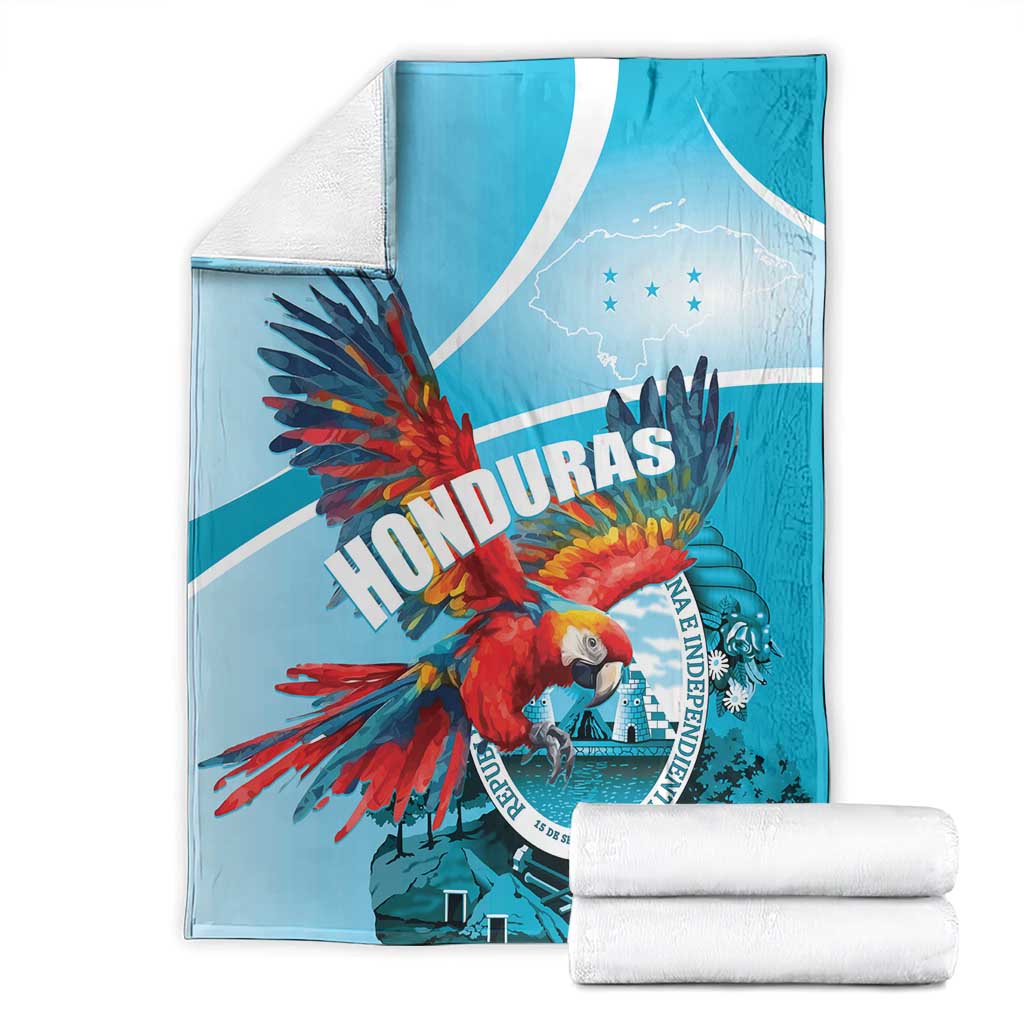 Stacked sky blue Honduras throw blanket set with red macaw print and circular emblem.
