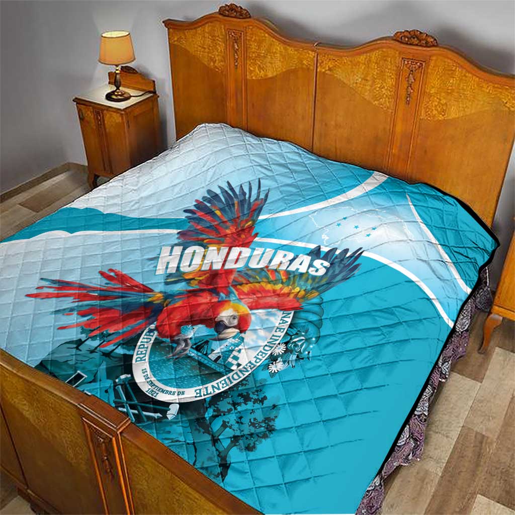 Blue and white Honduras quilt laid on a bed, featuring macaw emblem at center.