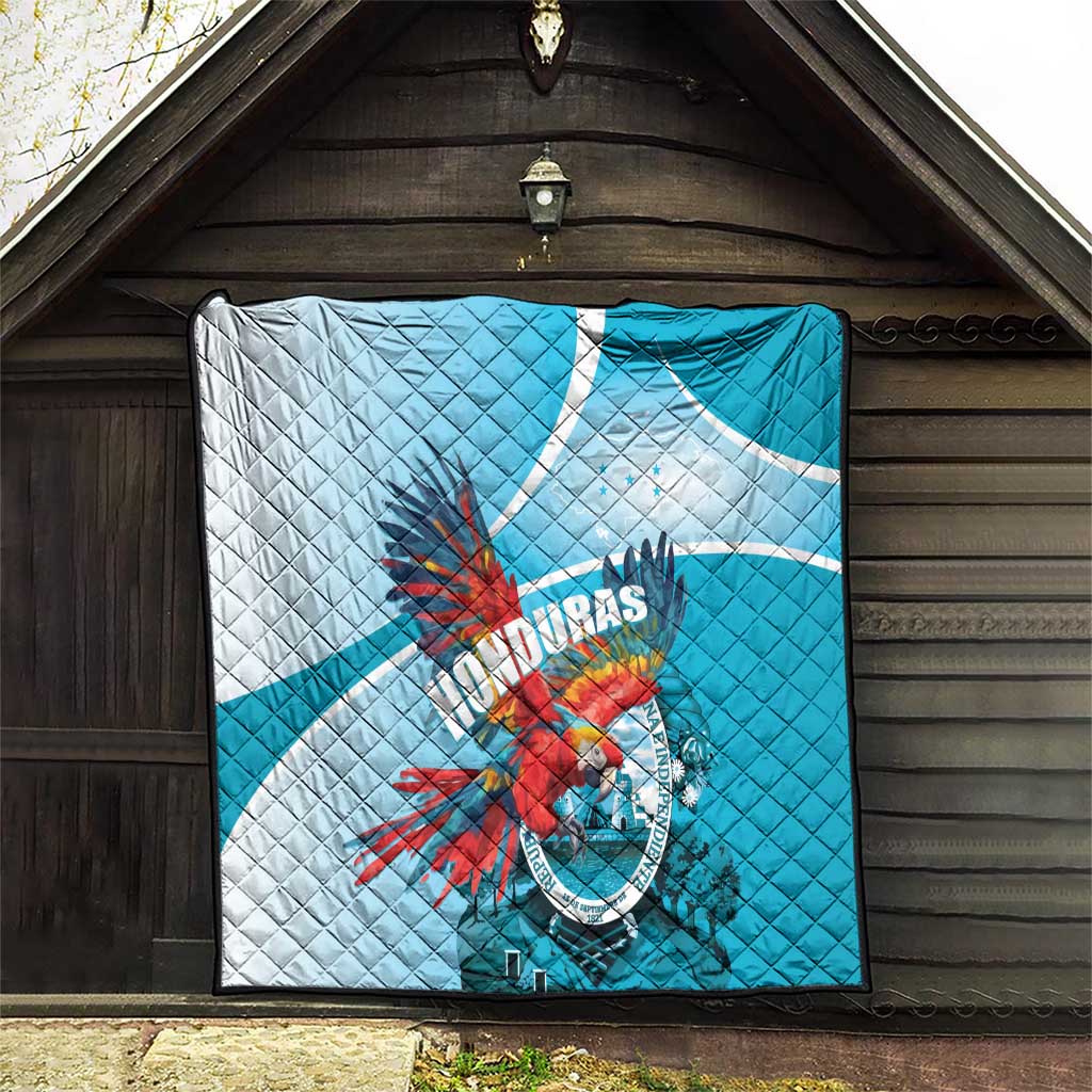Blue and white quilt with Honduras macaw emblem hanging on a wooden wall.
