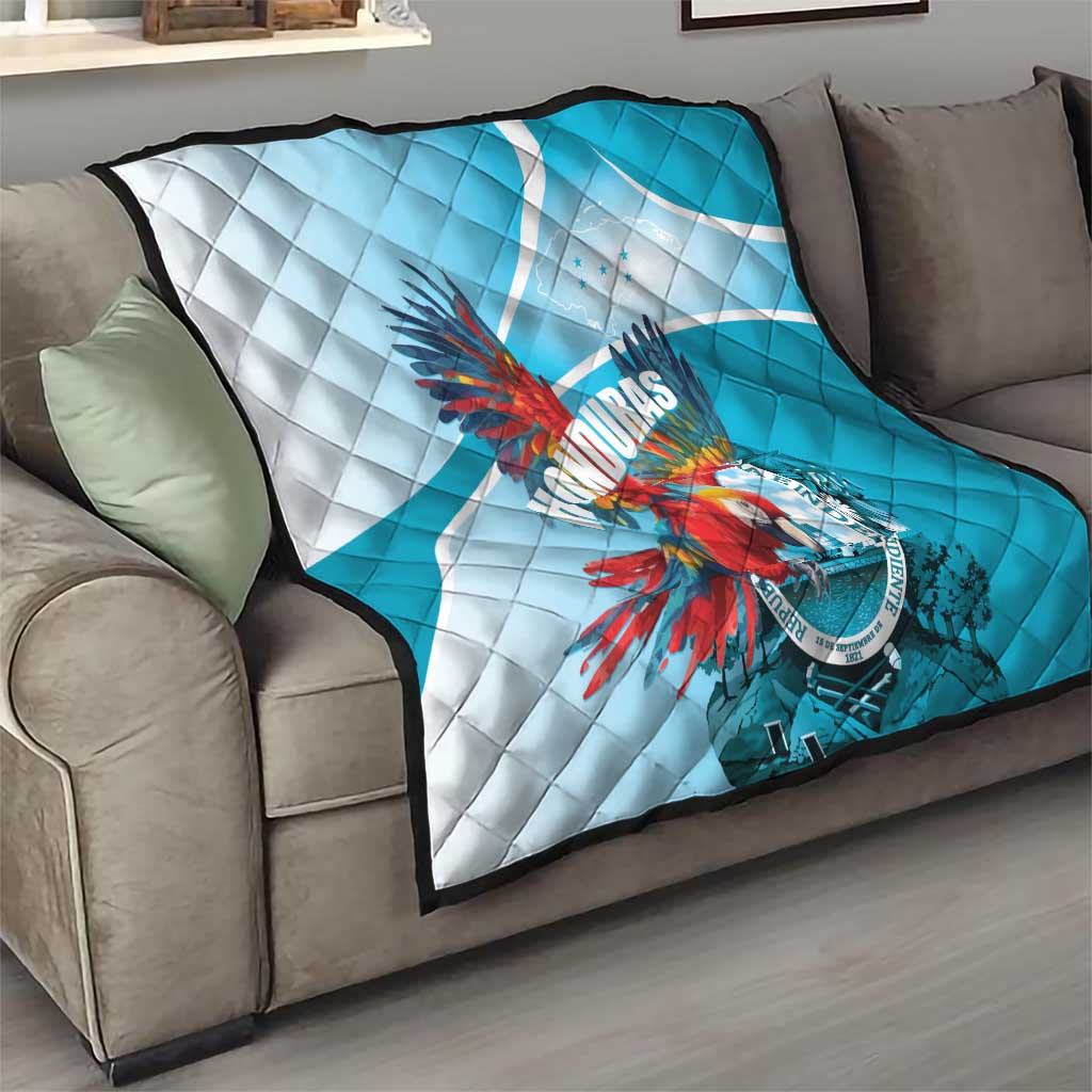 Blue and white quilt on couch with quilted diamond stitching and macaw Honduras logo.