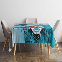 Teal-blue printed tablecloth with colorful top border and central coat-of-arms graphic