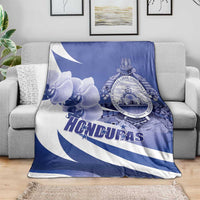 Honduras blanket throw with blue orchid floral print, circular coat of arms, and diagonal stripes