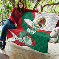 Mexico-themed quilt held over couch with eagle emblem and large teal floral designs
