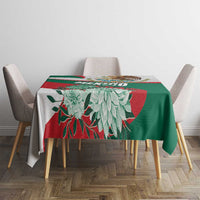 Tablecloth with green and red geometric blocks and large white floral illustration