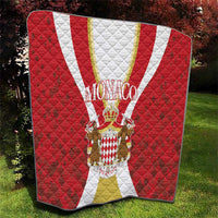 Red Monaco quilt blanket with white and gold stripe, centered crest and quilted diamond stitching