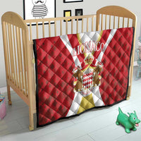 Red Monaco quilt in a baby crib, with white and gold stripe and crest emblem design