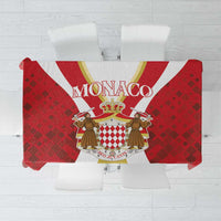 Red tablecloth with Monaco crest graphic and diamond-pattern border, square shape