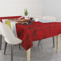 Red tablecloth with repeating diamond pattern and cut-corner drape over tabletop
