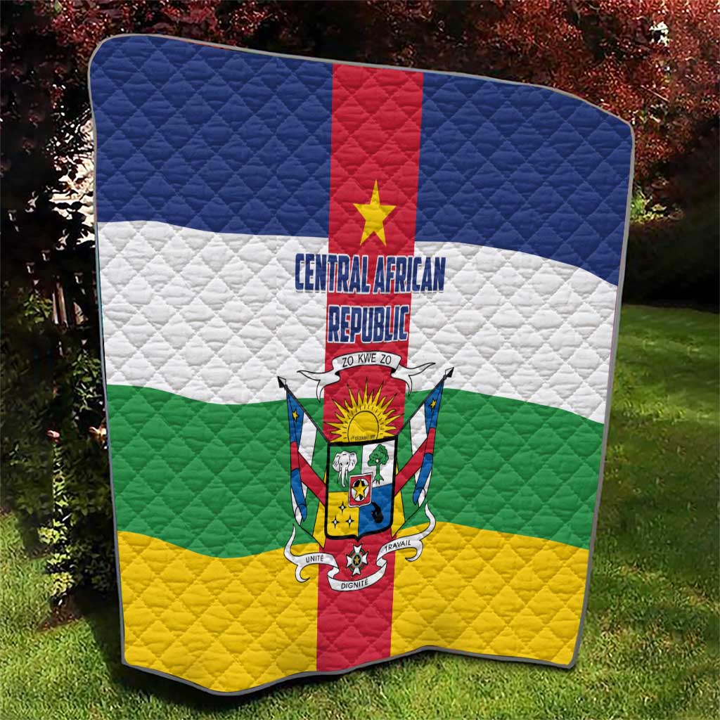 Central African Republic flag quilt on grass, quilted diamonds with red center stripe and crest