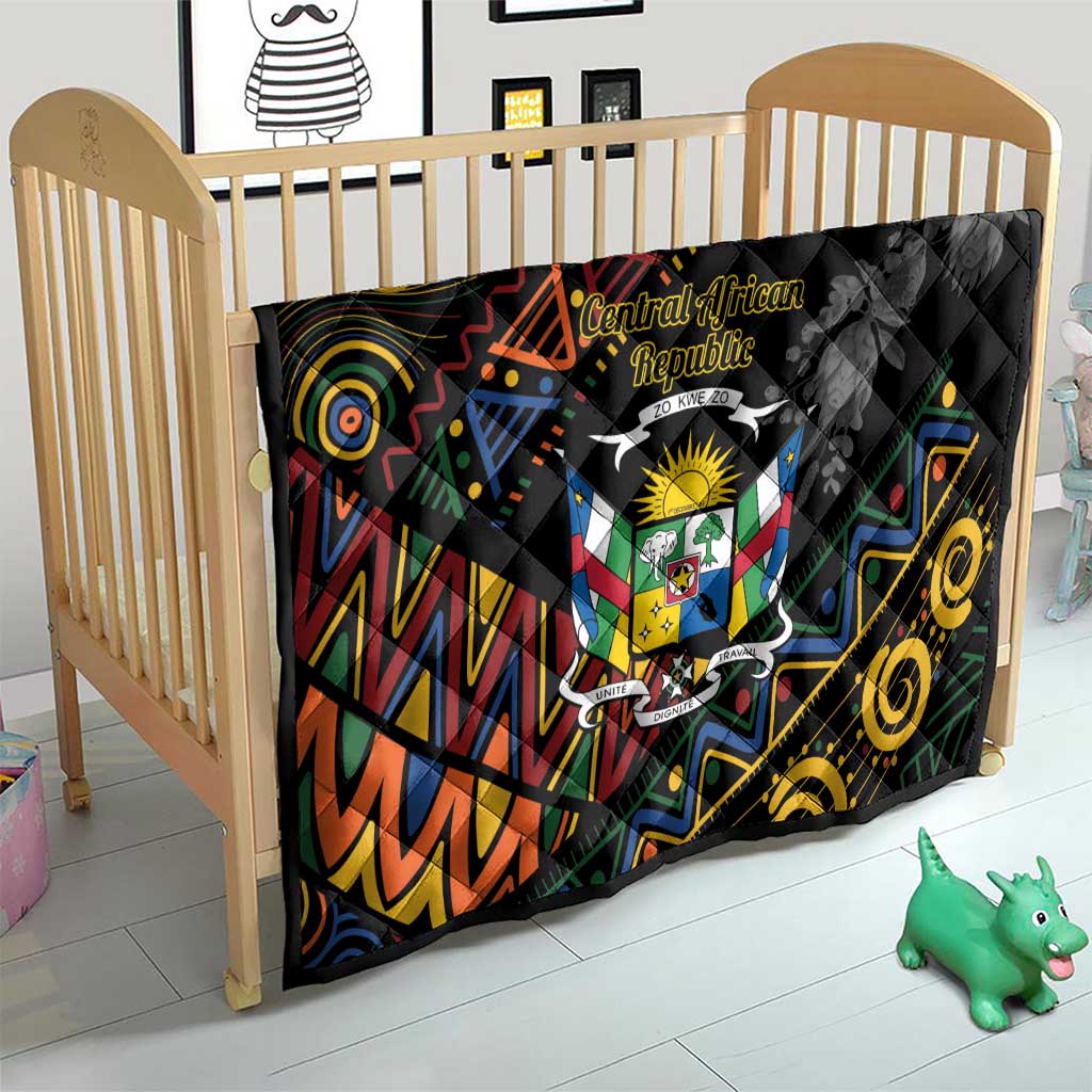 Black quilt blanket on crib with Central African crest emblem and colorful swirling geometric tribal design
