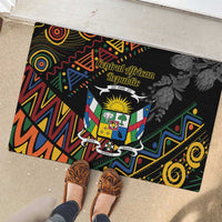 Black rubber doormat showing Central African Republic crest with protea flowers and zigzag pattern