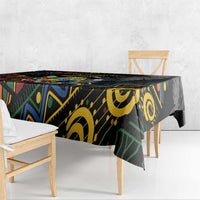 Black tablecloth with multicolor African pattern, hanging edge visible on dining table.