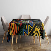 Black tablecloth with colorful African geometric design, centered on dining table.