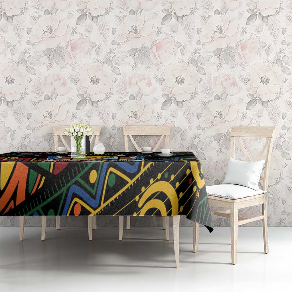 Black tablecloth with multicolor African geometric pattern on dining table with chairs.