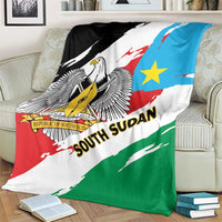 Flag-themed throw blanket on armchair showing eagle crest, blue star, and diagonal red-green