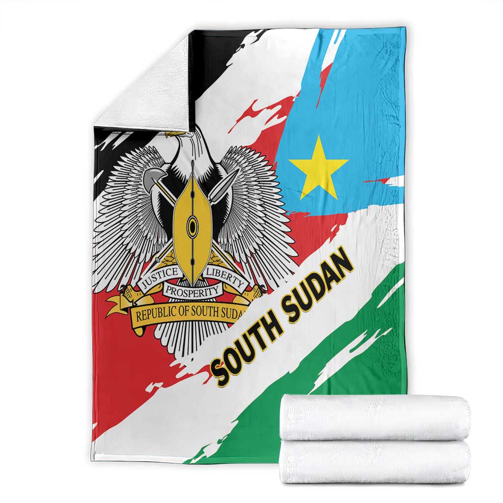 Flag-themed blanket folded beside white rolled towels; eagle crest, blue star, diagonal stripes