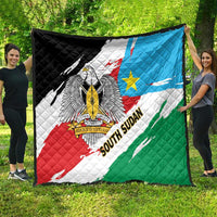 South Sudan flag quilt held outdoors, large eagle emblem over red, white, blue, and green.