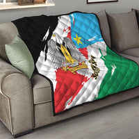 South Sudan flag quilt draped over a sofa cushion, showing eagle emblem and tricolor bands.