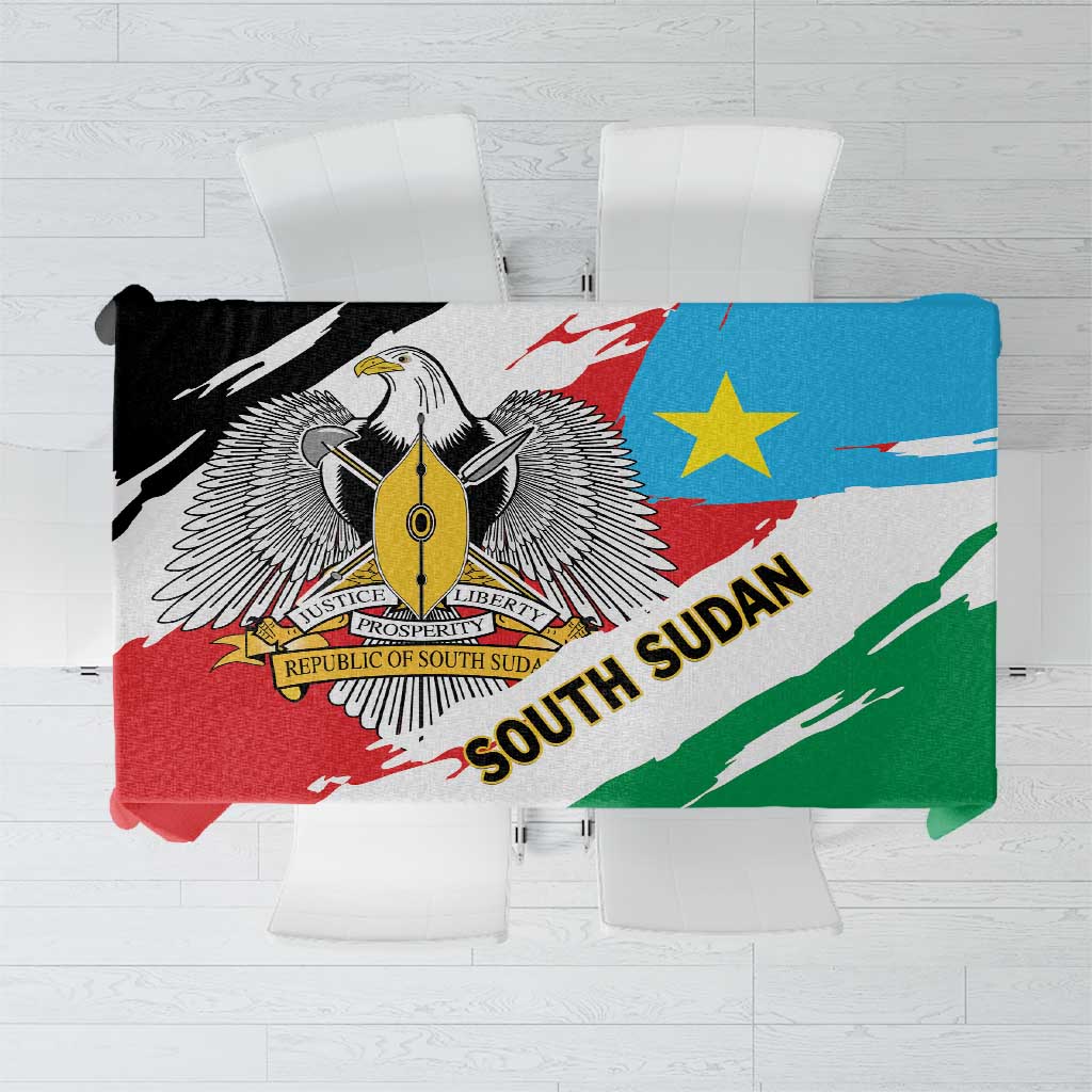 South Sudan flag grunge tablecloth folded, green red blue with emblem and text