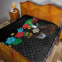 Black quilt on bed featuring colorful hibiscus flowers and eagle wing motif
