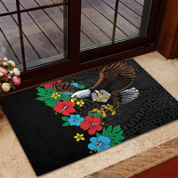 Black rubber doormat with hibiscus floral design and large bird wings over geometric motifs