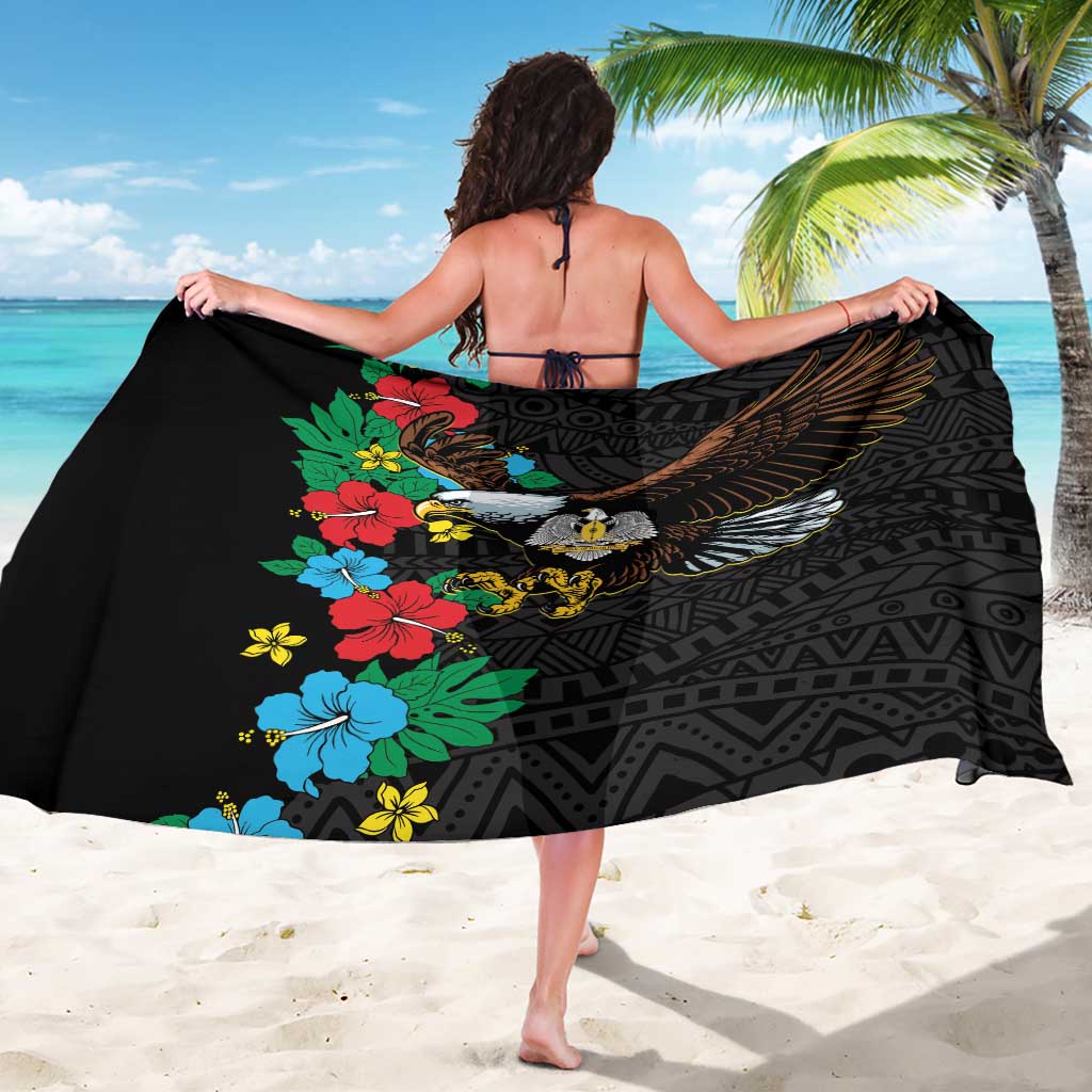 Black African sarong worn as wrap, hibiscus flowers and eagle graphic over geometric design