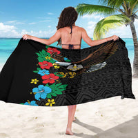 Black African sarong worn as wrap, hibiscus flowers and eagle graphic over geometric design