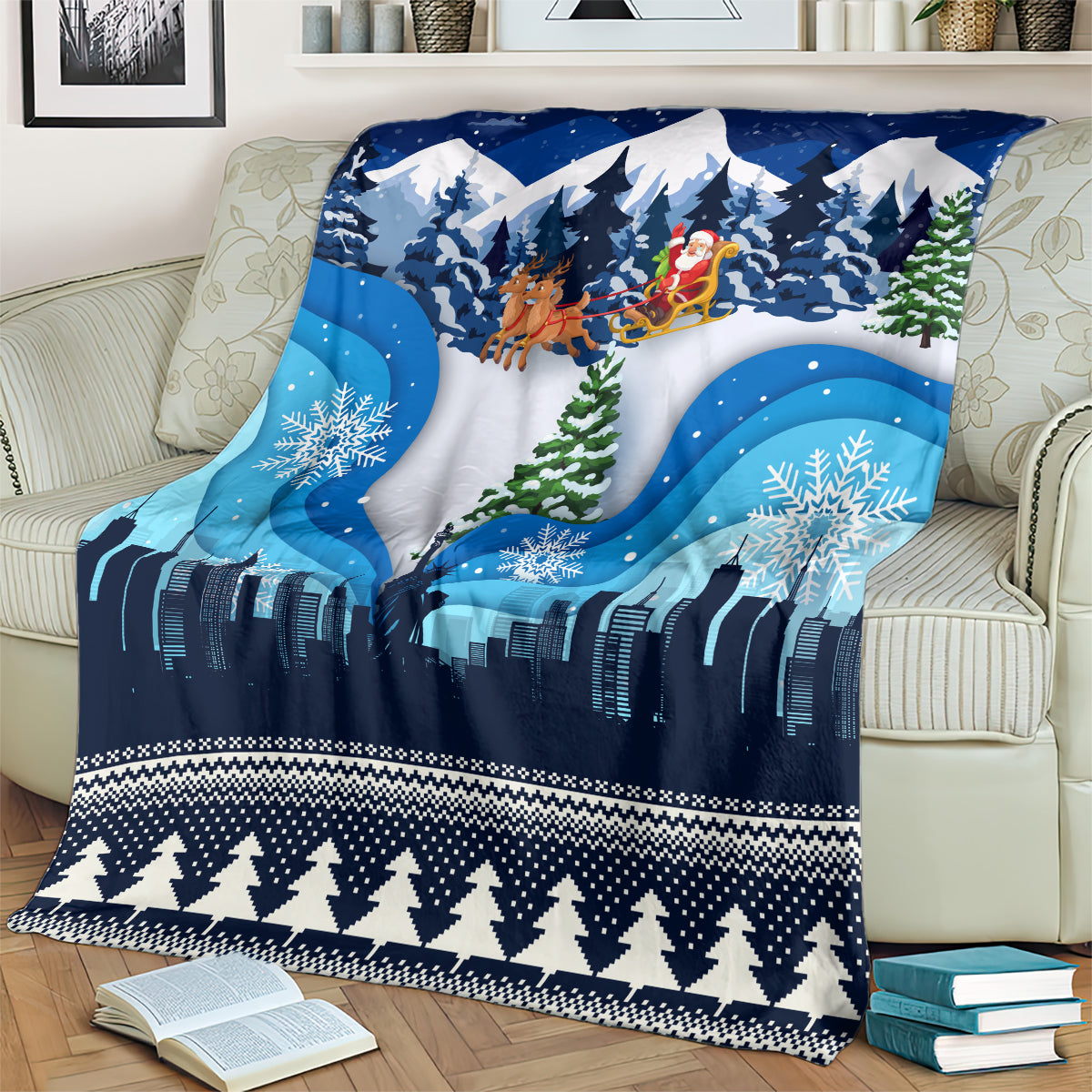 Blue Christmas blanket draped on sofa, featuring skyline lights and snowy pine trees.