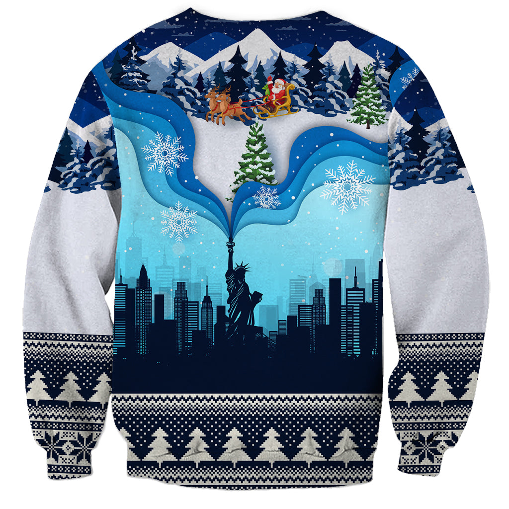 Blue unisex crewneck sweatshirt with snowy skyline, Liberty statue, and festive border cuffs