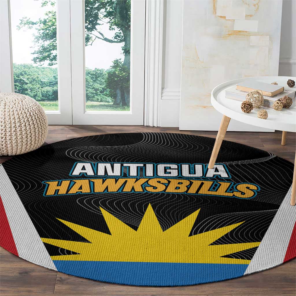 Round black rug with Antigua Hawksbills logo, yellow sunburst, blue outer band