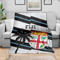 Fiji rugby blanket draped on sofa with white pattern, blue stripes, and shield emblem