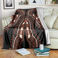 African dashiki pattern vintage blanket, black with orange tribal motifs, draped on sofa