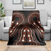 Black dashiki patterned vintage blanket with ornate orange figure, spread on couch
