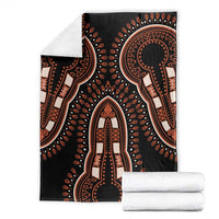 Black dashiki pattern vintage blanket with orange motifs, folded with white fabric rolls