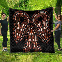 Black quilt featuring orange and white dashiki elephant silhouettes, full throw on grass
