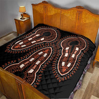 Black dashiki-style quilt with orange and white elephant motifs on bed, diamond quilting