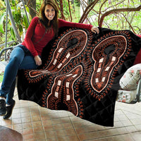 Black dashiki quilt with orange and white elephant motifs spread out, quilted pattern