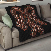 Black quilt throw with orange and white elephant silhouettes on sofa, diamond-quilted