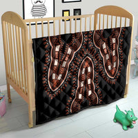 Black quilt on a wooden crib with orange and white elephant dashiki motifs, quilted
